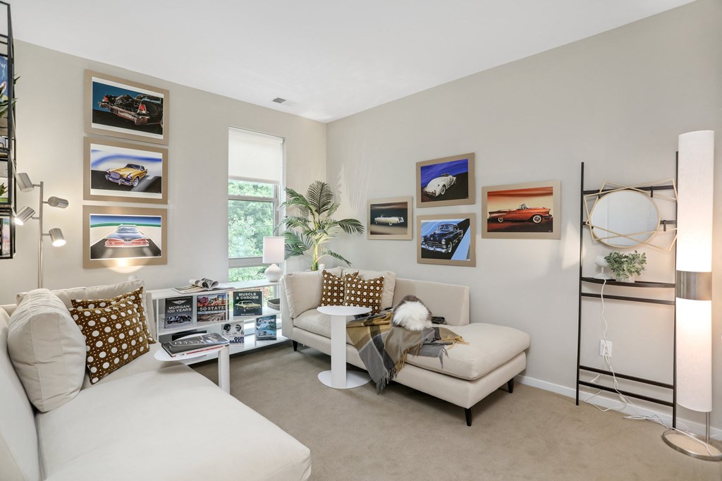 a living room with a couch and a chair and pictures on the wall