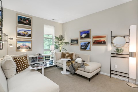 a living room with a couch and a chair and pictures on the wall