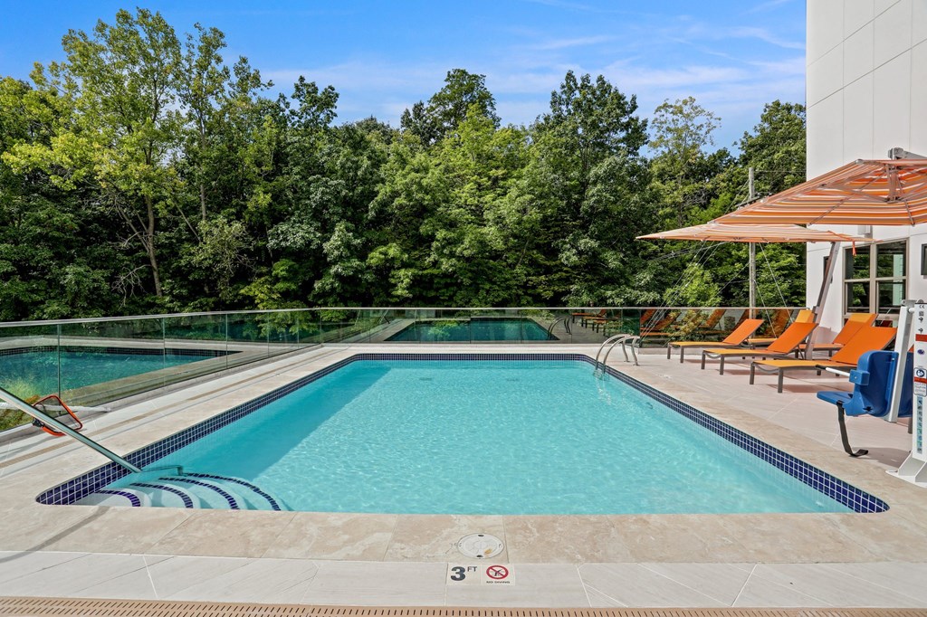 a swimming pool with orange chairs and a poolside cabana and a resort pool