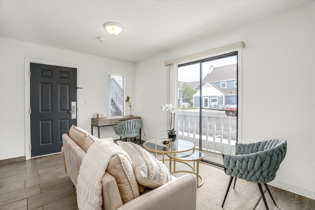 a living room with a couch and chairs and a glass table