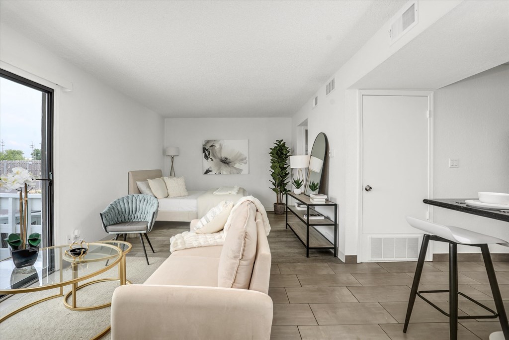 a living room with white furniture and a sliding glass door