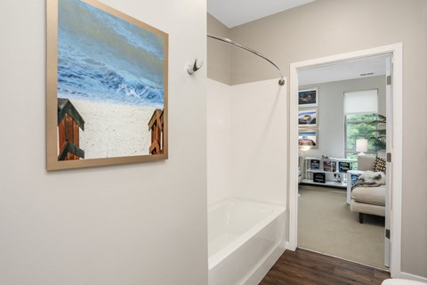 a bathroom with a shower and a painting on the wall