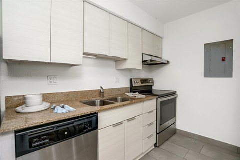 a kitchen with white cabinets and a counter top and a sink