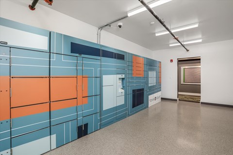 a hallway with blue and orange lockers and a white wall with a door