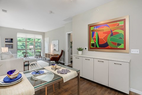 a living room with white cabinets and a table with chairs and a couch