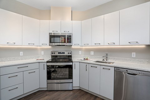 a kitchen with white cabinets and stainless steel appliances