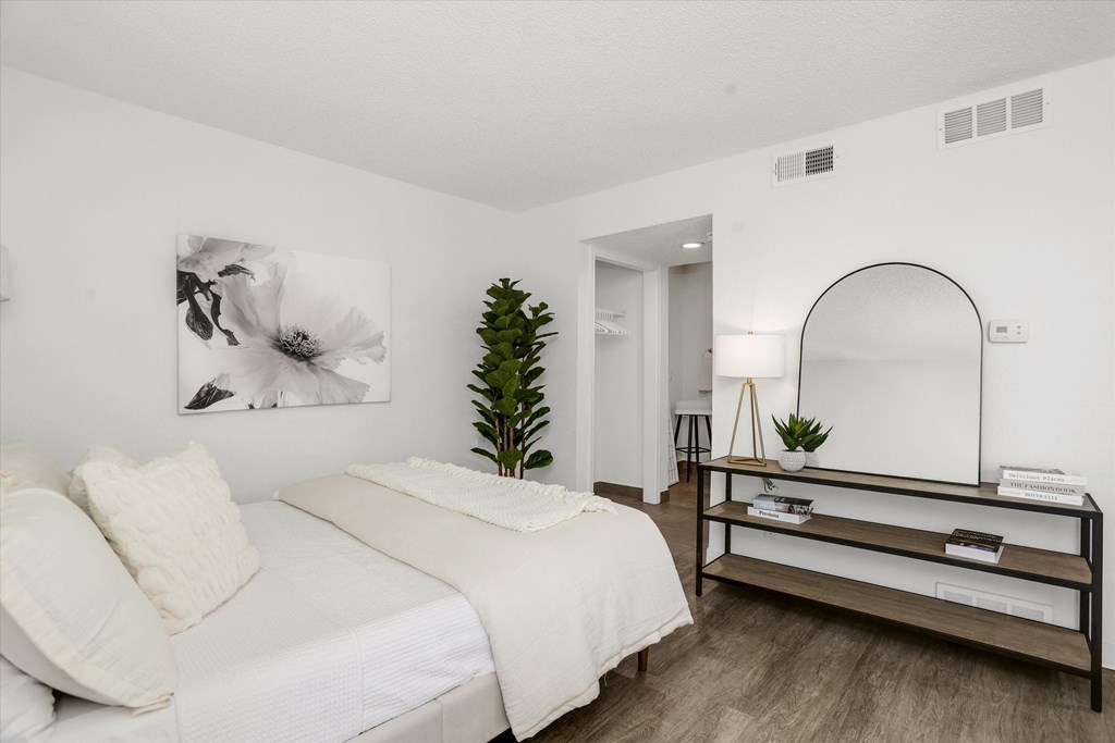 a bedroom with a large white bed and a mirror