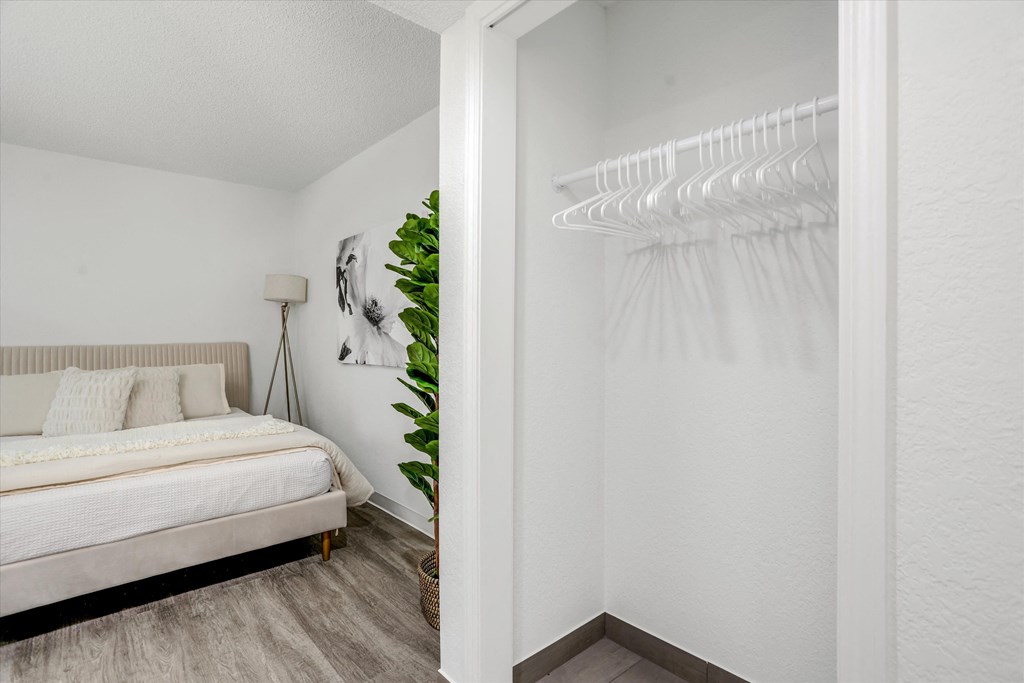 a bedroom with white walls and a bed and a white closet