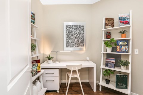 a home office with a desk and a chair and shelves