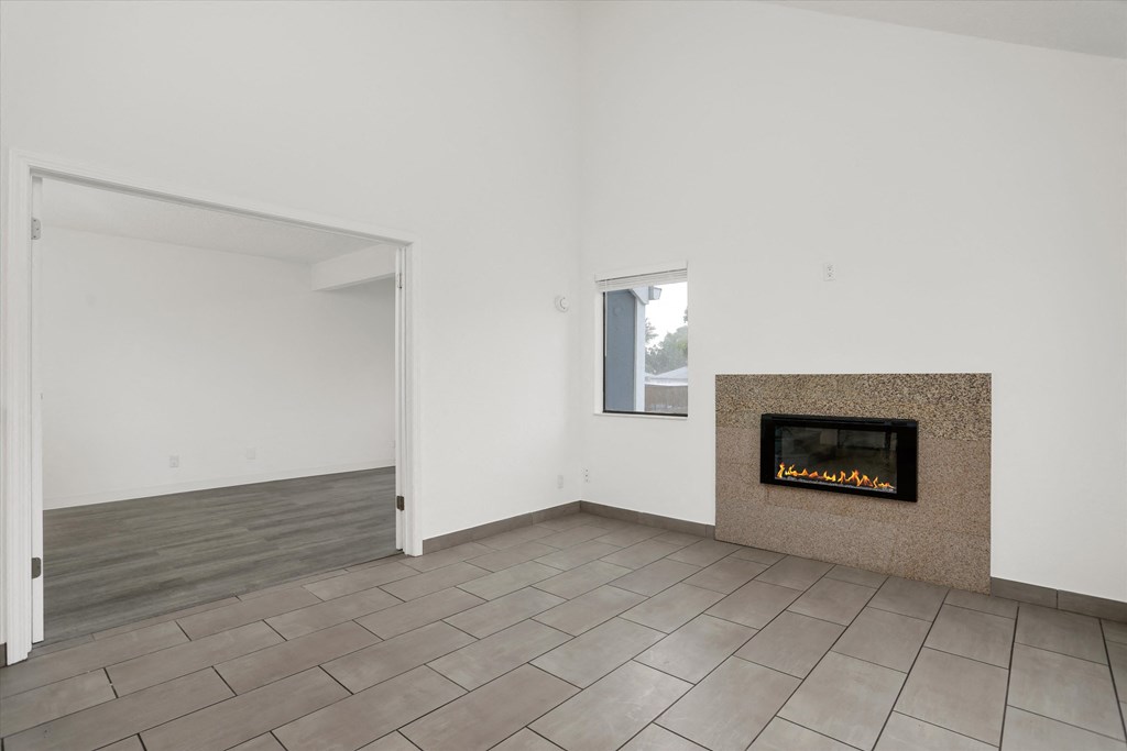 a living room with a fireplace and tiled floors
