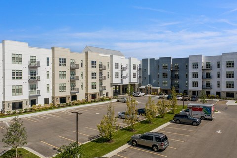 an aerial view of an apartment complex with cars parked in a parking lot