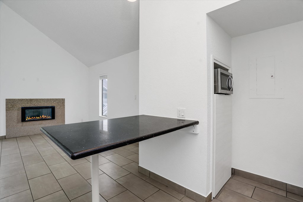 a kitchen with a black counter top and a fireplace