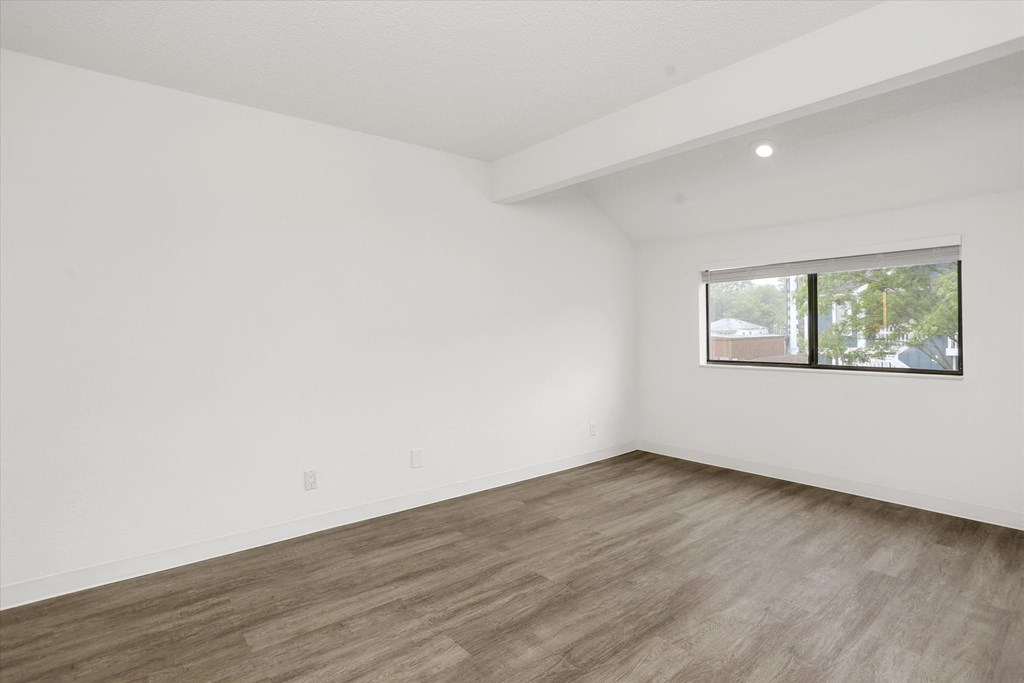 an empty room with white walls and a window