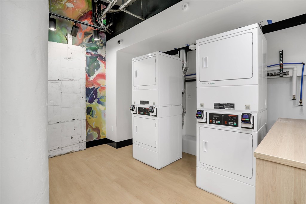 A room with a white wall and a washing machine.