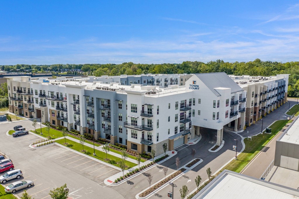 an aerial view of an apartment building with cars parked in front of it