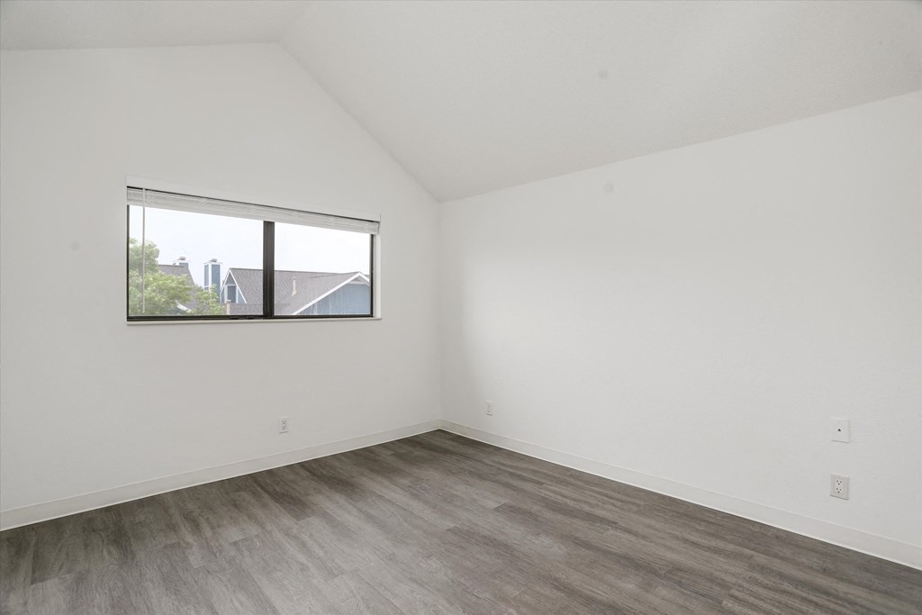 an empty room with white walls and a window