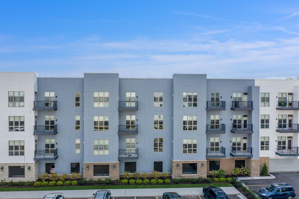 a large apartment building with cars parked in front of it