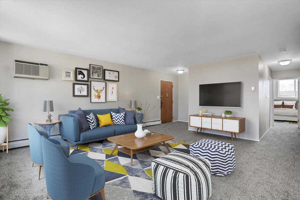 a living room with blue couches and a yellow and blue rug