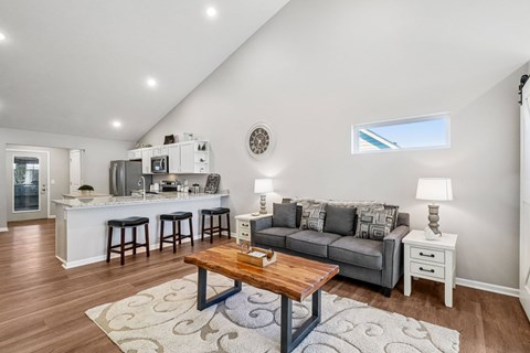 A living room with a grey couch and a wooden coffee table.