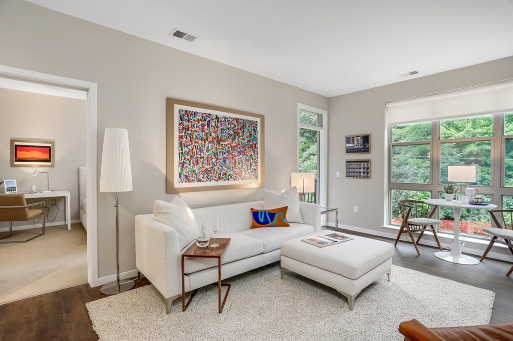 a living room with a white couch and a white ottoman