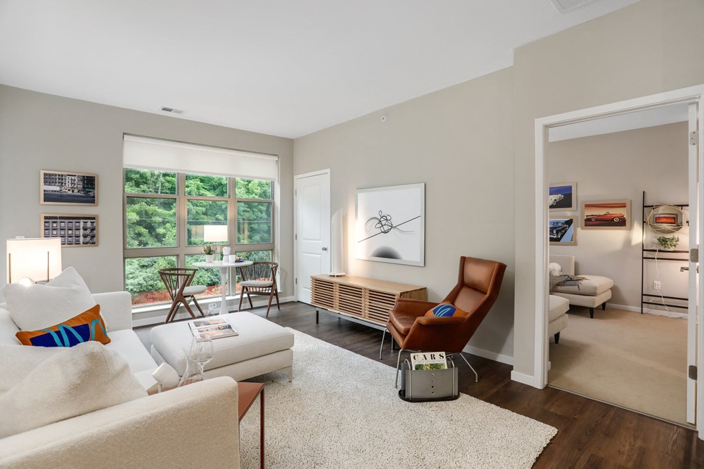 a living room with a couch and a chair and a door to a bedroom