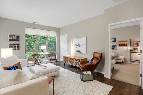 a living room with a couch and a chair and a door to a bedroom