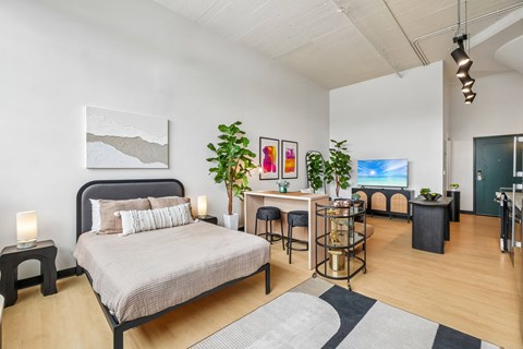 A bedroom with a large bed and a desk with a chair.