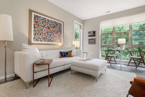 a living room with a white couch and a chair and a large window