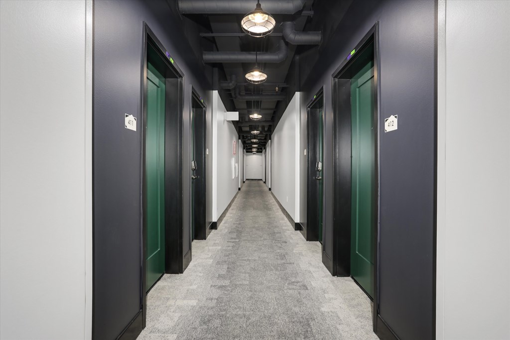 A long hallway with doors on both sides and a light on the ceiling.
