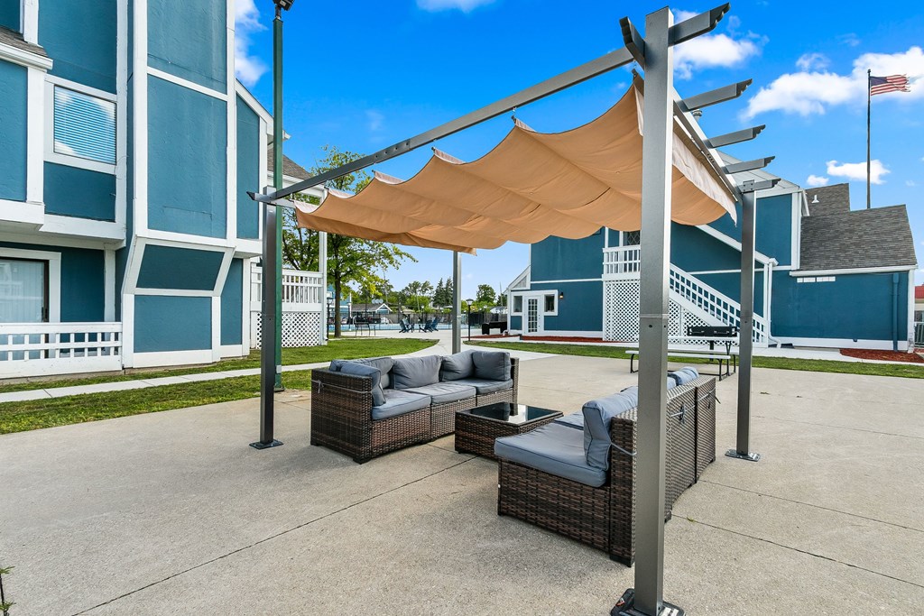 A patio with a couch and a table under a canopy.