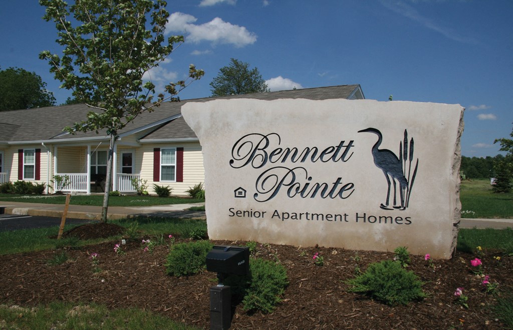A stone sign for Bennett Pointe Senior Apartment Homes is in the foreground.