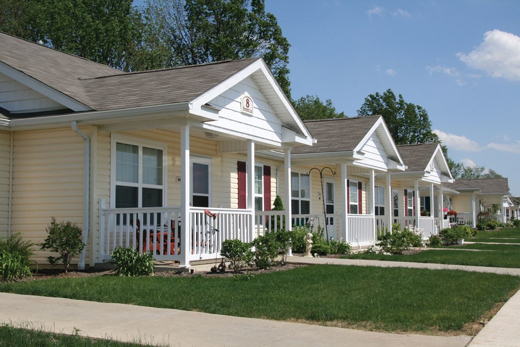 a row of houses in a neighborhood with a sidewalk and grass