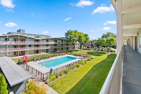 A view of a pool and apartment complex from a balcony.