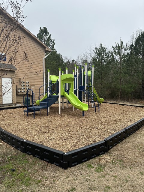 Playground with slides and wood chip surfacing at Lifestyle at the Bay Apartments, Gulfport, MS