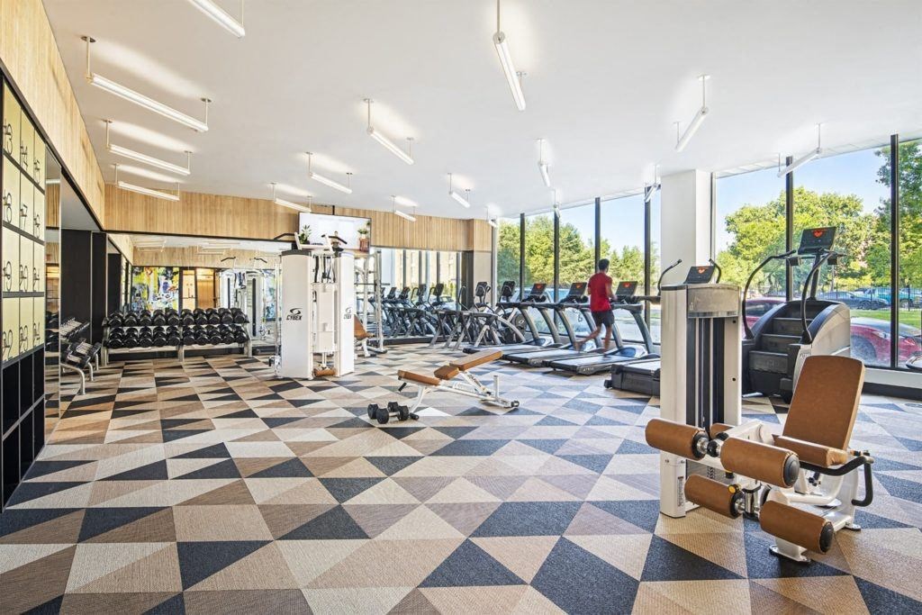 a gym with cardio machines and weights on a checkered floor
