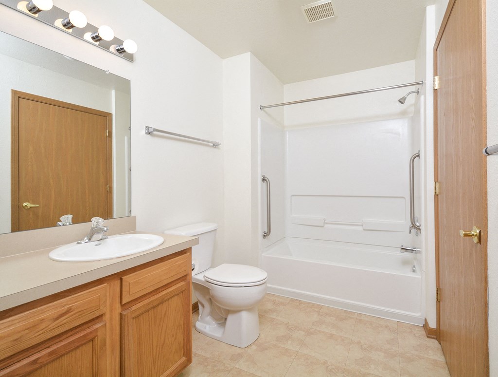A white toilet sits next to a sink in a bathroom.