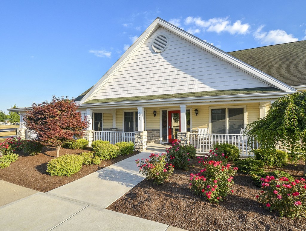 A white house with a red door and a small porch.