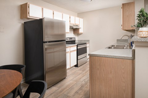 a kitchen with stainless steel appliances and a table and chairs