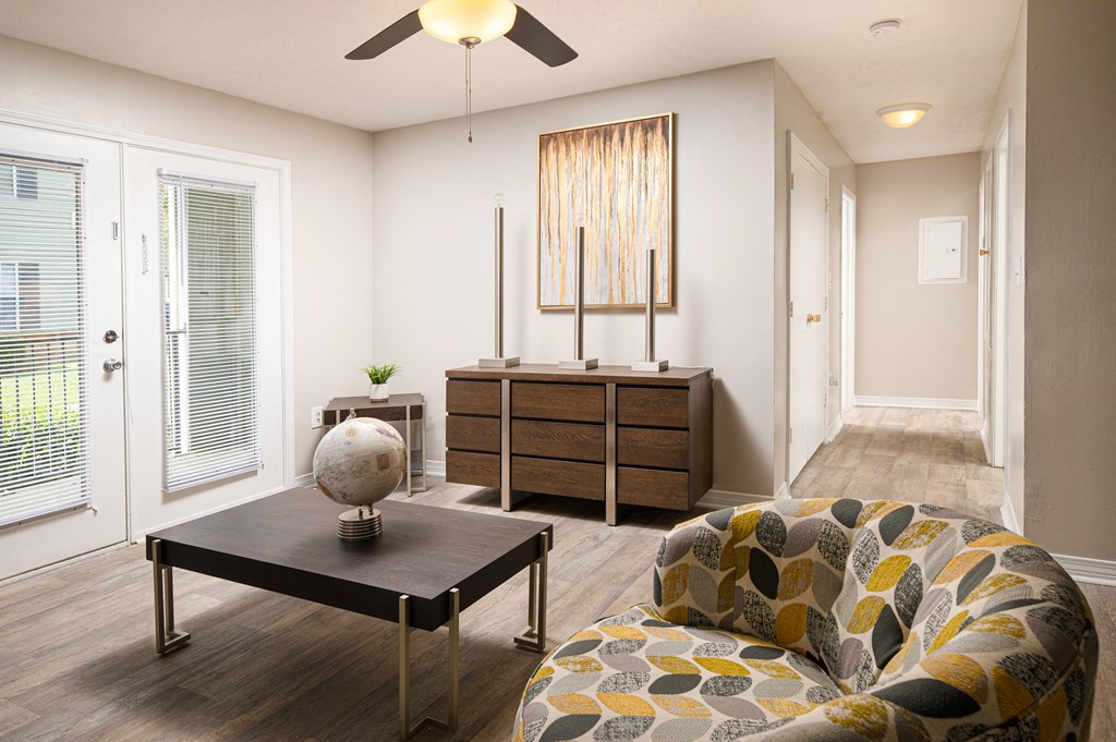 a living room with a ceiling fan and a door leading to a hallway