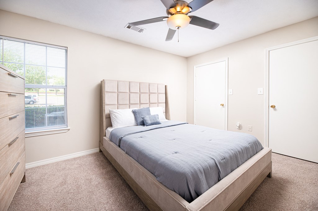 a bedroom with a bed and a ceiling fan