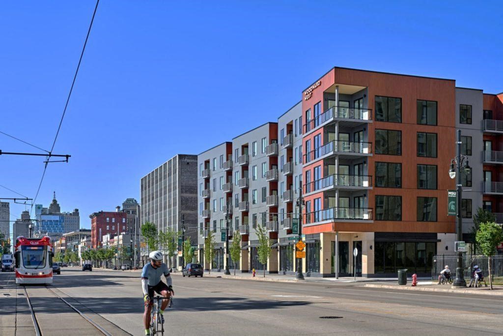 a man riding a bike down a street in front of a building