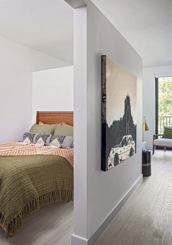 a bedroom with a bed and a painting on the wall