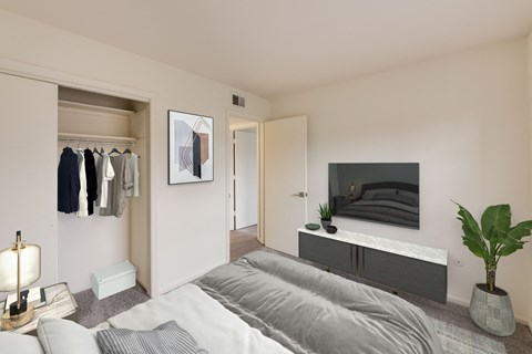 A bedroom with a large bed and a TV on the wall.