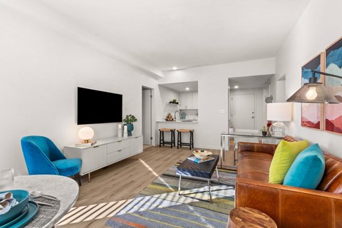 A living room with a blue chair and a brown couch.