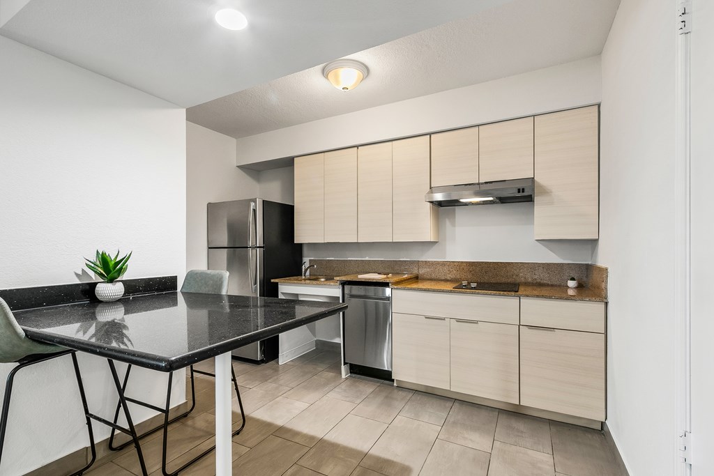 A modern kitchen with a black table and a refrigerator.