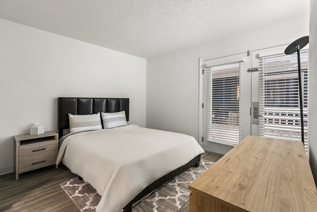 A bedroom with a large bed and a wooden table.