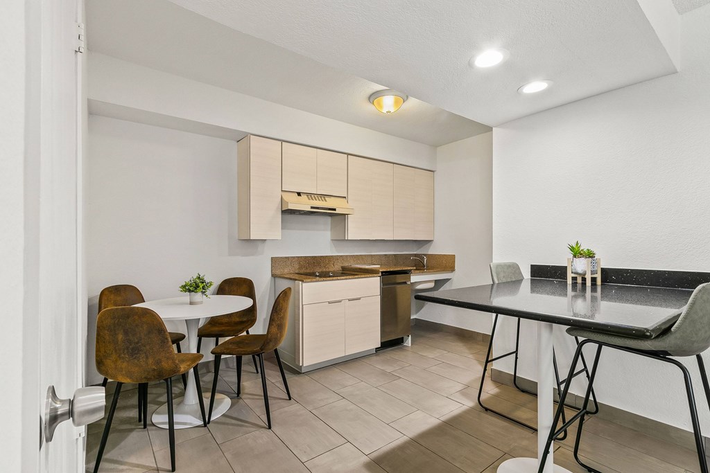 A modern kitchen with a dining table and chairs.