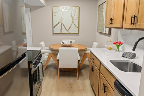 A modern kitchen with a wooden table and chairs.