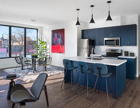 A modern kitchen with blue cabinets and a white island.