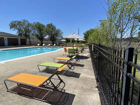 a row of lounge chairs next to a swimming pool
